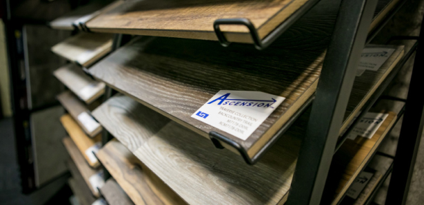 Close-up of wood-look flooring samples labeled Ascension