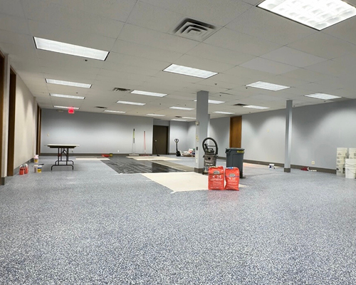 Large room mid-renovation with tools and flooring materials