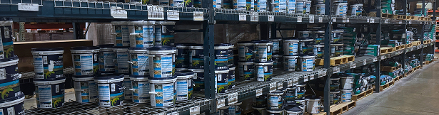 Shelves stocked with adhesive buckets in a warehouse